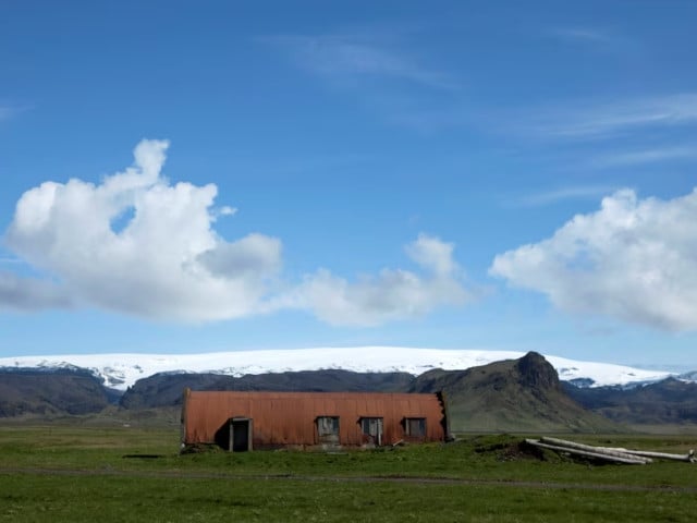 a farm building stands in a field below the myrdalsjokull glacier that covers the katla volcano in evindarholar iceland may 28 2011 photo reuters